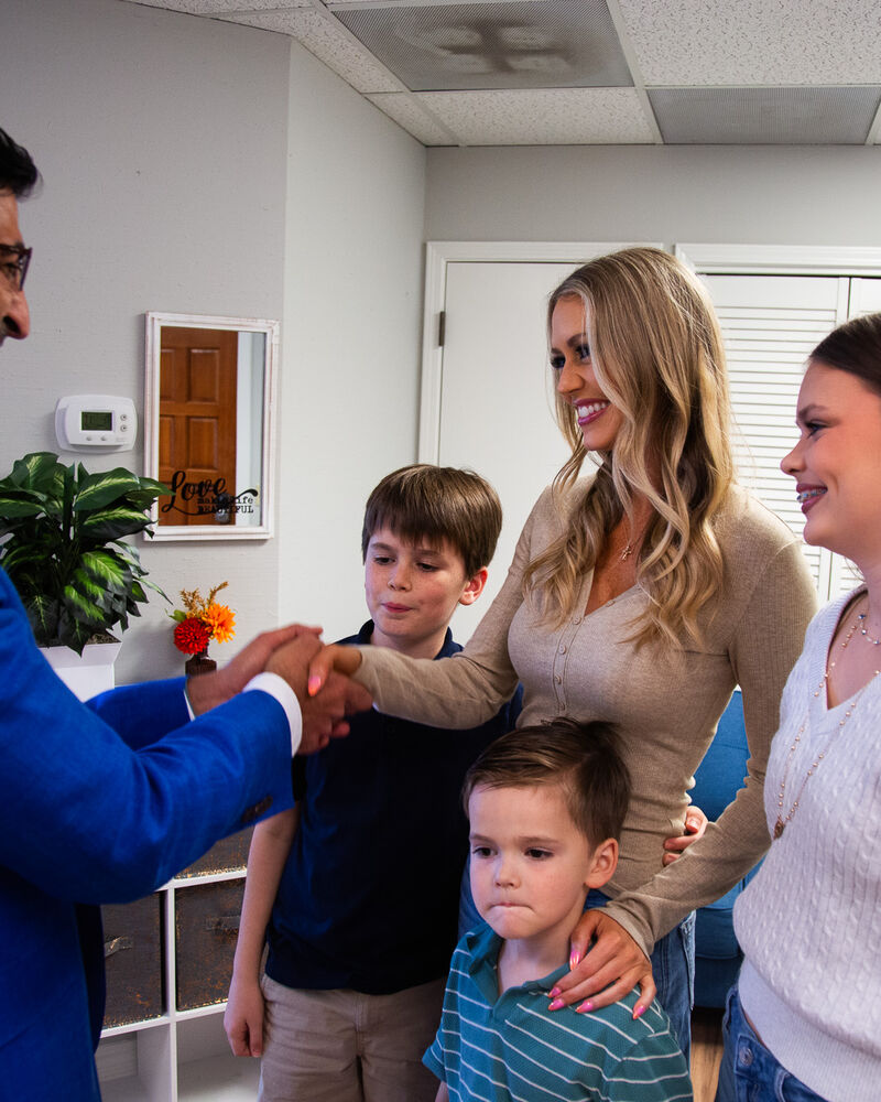 Dr. Loungani greeting a mother and her three children