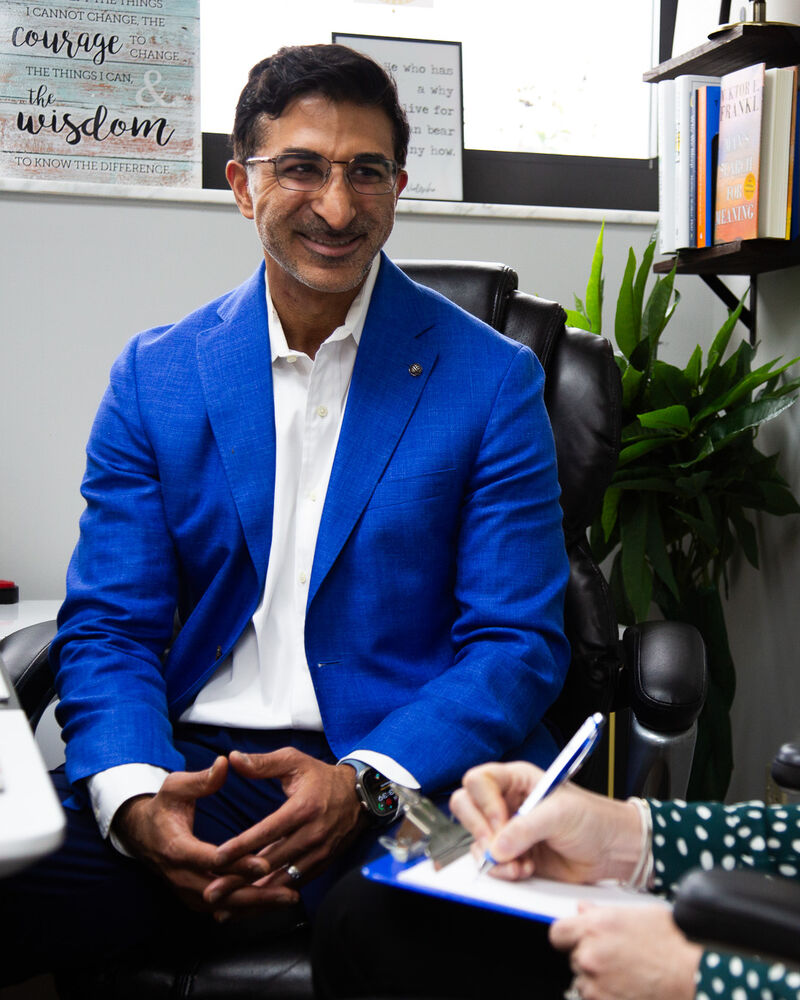 Dr. Loungani talking through a case while a nurse practitioner takes notes