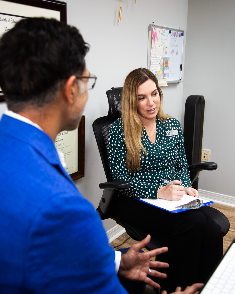 Dr. Loungani explaining a treatment plan to a nurse practitioner with a clipboard