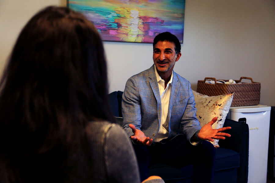 A visitor talking with Dr. Loungani in his office