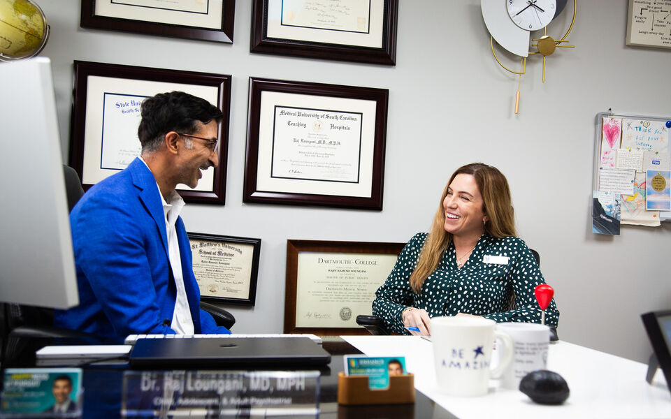 Dr. Loungani at his desk with his board certifications on the wall